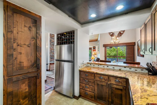 a kitchen with refrigerator a stove and a window