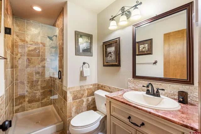 a bathroom with a granite countertop sink a mirror a bathtub and toilet
