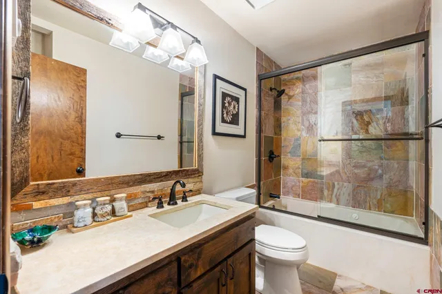 a bathroom with a sink vanity mirror and toilet