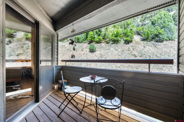 a patio with wooden floor table and chairs