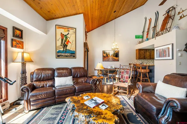 a living room with furniture a couch and paintings on the wall