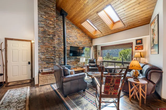 a living room with furniture a wooden floor and next to a window