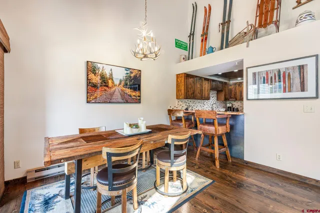 a view of a dining room with furniture a chandelier and wooden floor