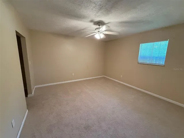 en empty room with windows and fan