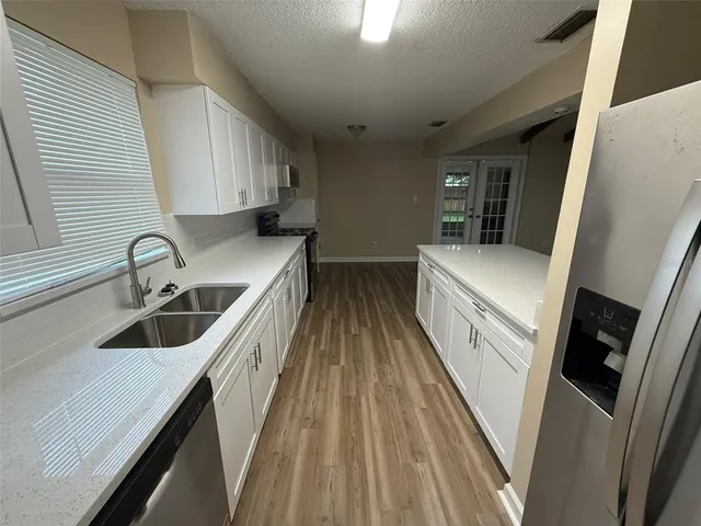 a kitchen with a sink a counter top space stainless steel appliances and a window