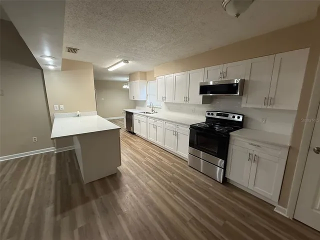 a kitchen with kitchen island white cabinets appliances and sink