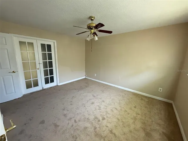 an empty room with a empty space and a ceiling fan