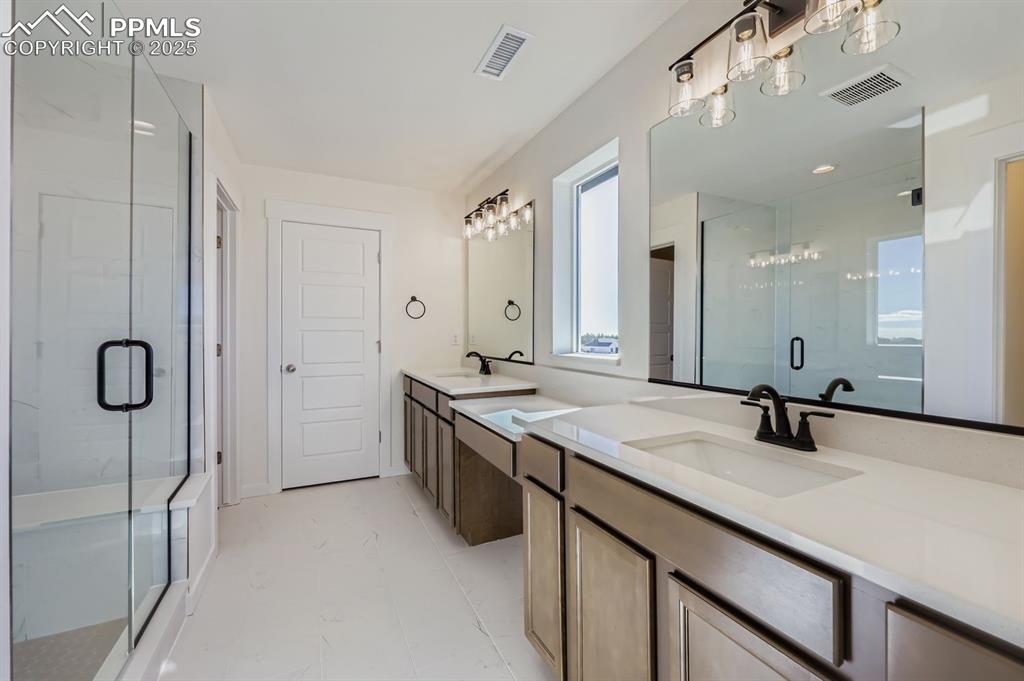 7989 Polson Drive Colorado Springs, CO 80908 - Photo 14 of 28 Bathroom featuring double vanity and a stall shower