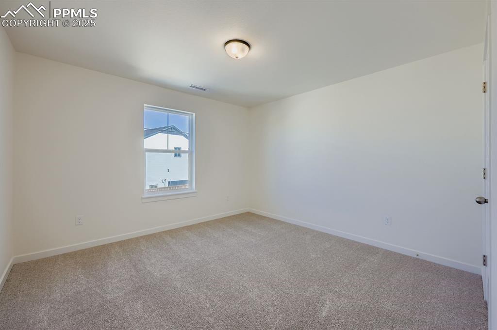 7989 Polson Drive Colorado Springs, CO 80908 - Photo 19 of 28 Empty room with light colored carpet and baseboards