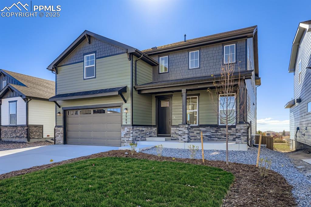 7989 Polson Drive Colorado Springs, CO 80908 - Photo 2 of 28 Craftsman-style home featuring stone siding, an attached garage, covered porch, concrete driveway, and a front yard