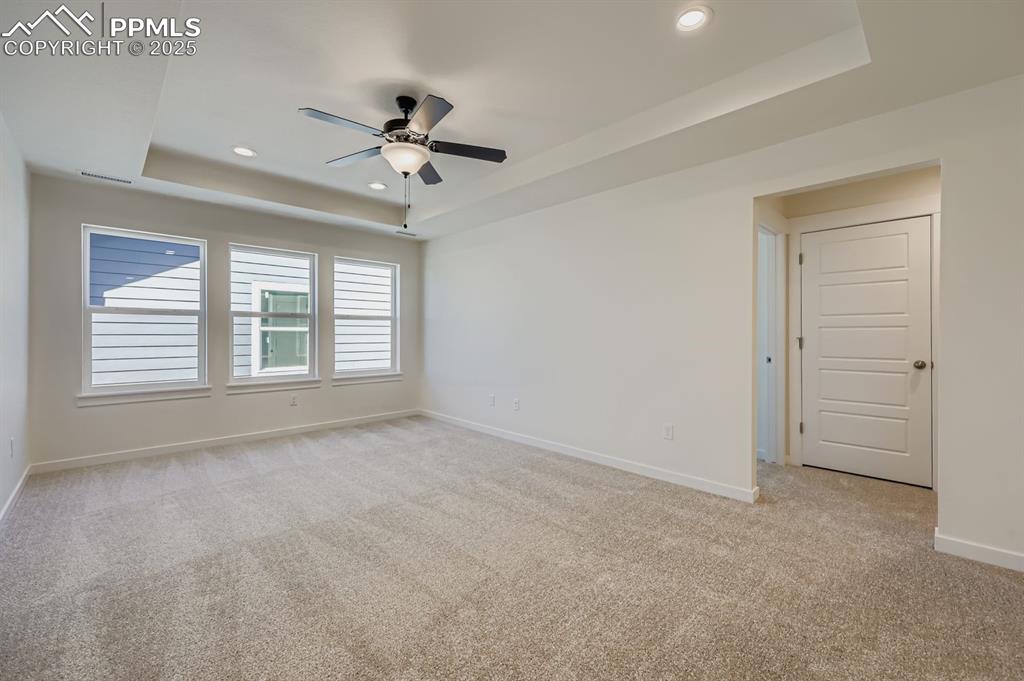 7989 Polson Drive Colorado Springs, CO 80908 - Photo 22 of 28 Spare room featuring a raised ceiling, light carpet, recessed lighting, and ceiling fan