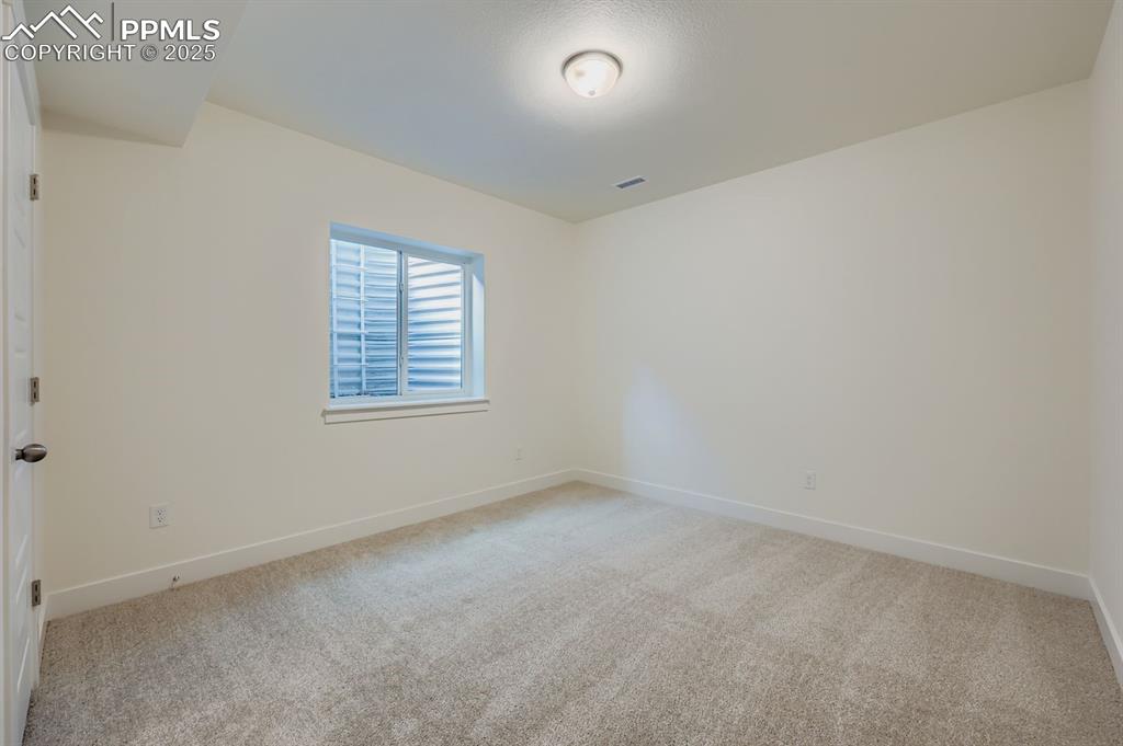 7989 Polson Drive Colorado Springs, CO 80908 - Photo 24 of 28 Empty room featuring baseboards and light colored carpet
