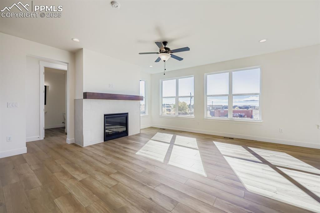 7989 Polson Drive Colorado Springs, CO 80908 - Photo 5 of 28 Unfurnished living room featuring recessed lighting, a fireplace, light wood-type flooring, and ceiling fan