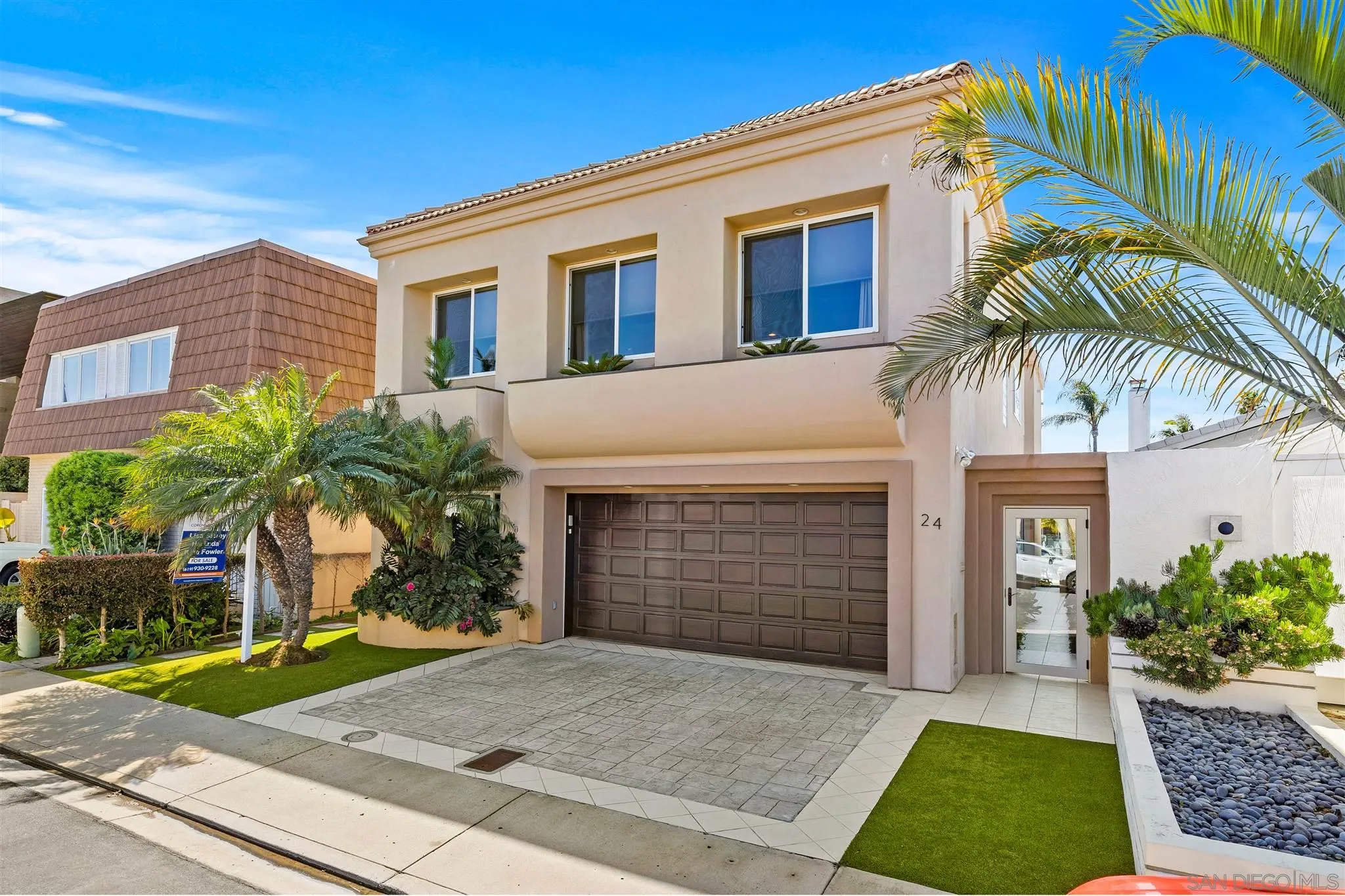 24 Sandpiper Strand Coronado, CA 92118 - Photo 5 of 55 a front view of a house with a yard and garage