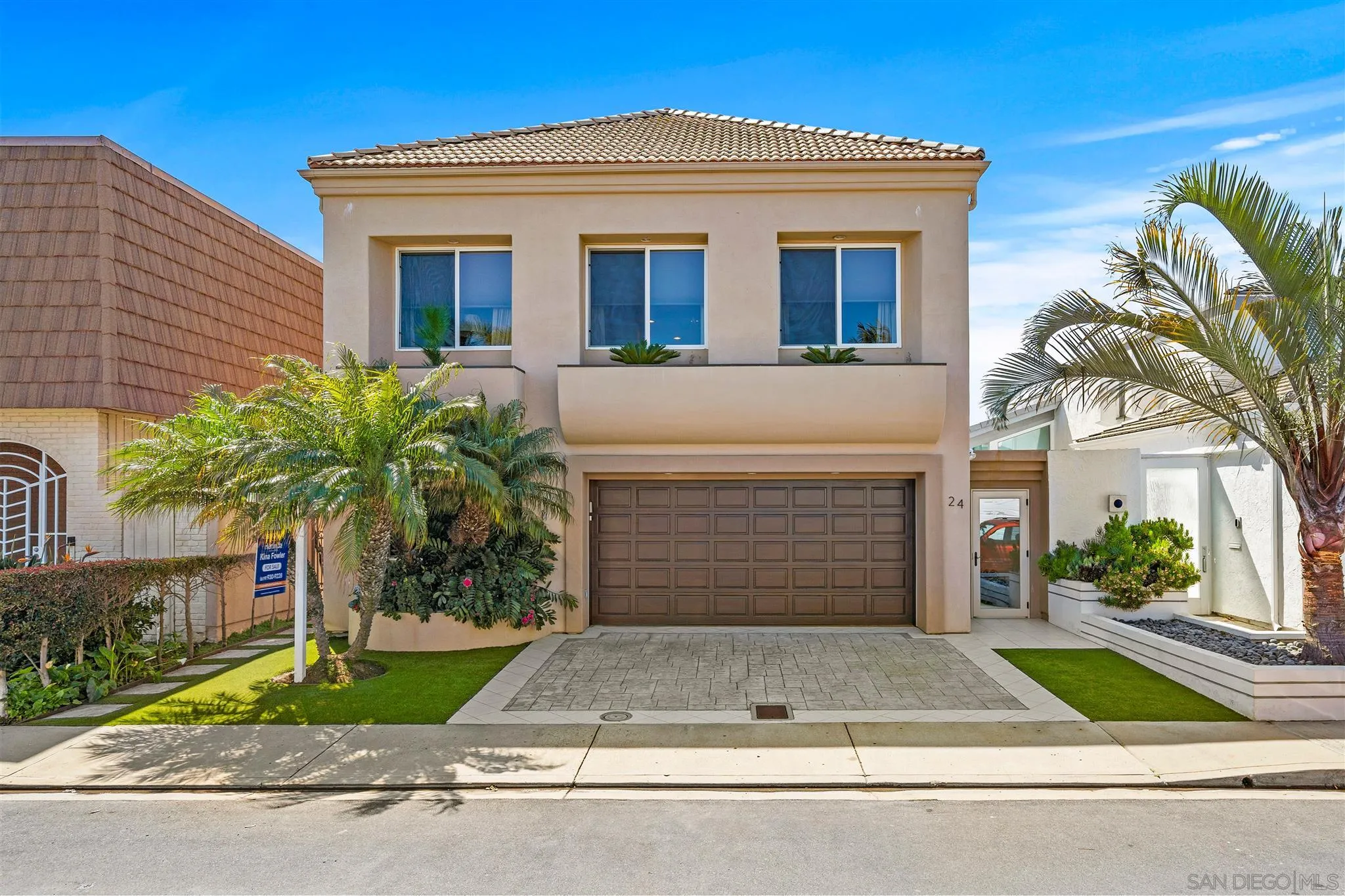 24 Sandpiper Strand Coronado, CA 92118 - Photo 6 of 55 a front view of a house with a yard and garage