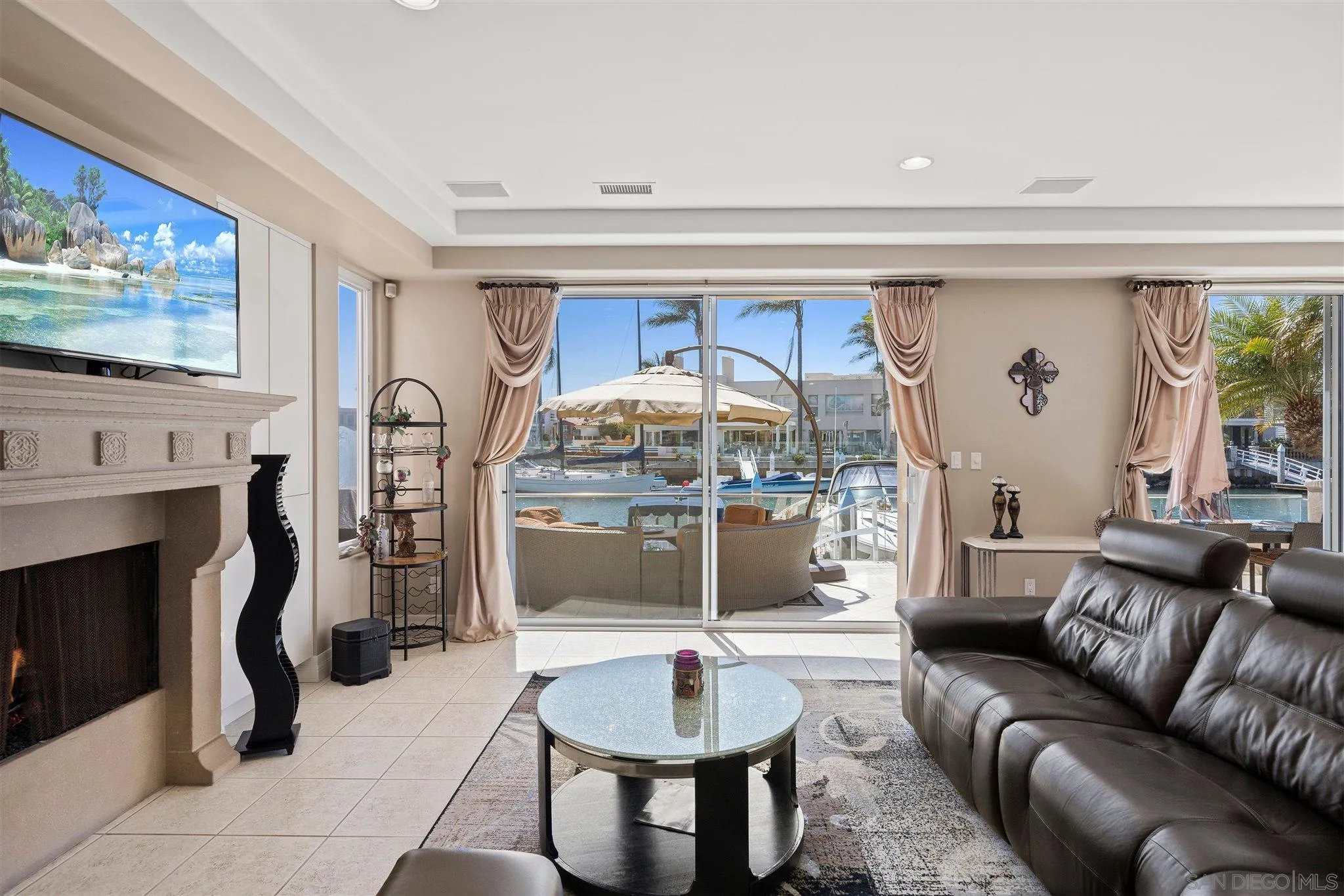 24 Sandpiper Strand Coronado, CA 92118 - Photo 9 of 55 a living room with furniture a flat screen tv and a fireplace