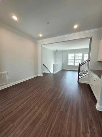a view of empty room with wooden floor