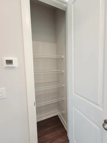 a view of walk in closet with empty racks