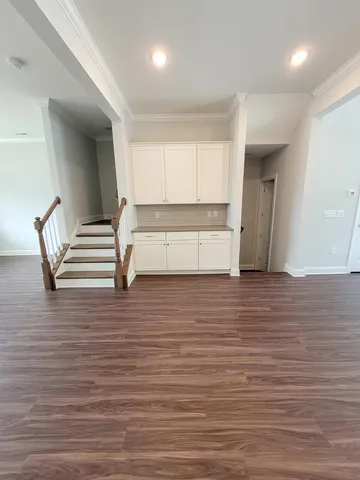 a view of a livingroom with wooden floor and stairs