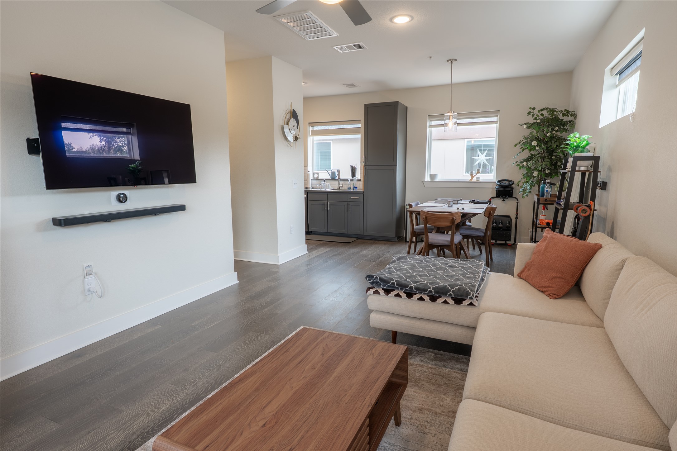 The living area features hardwood style flooring, recessed lighting, and a ceiling fan