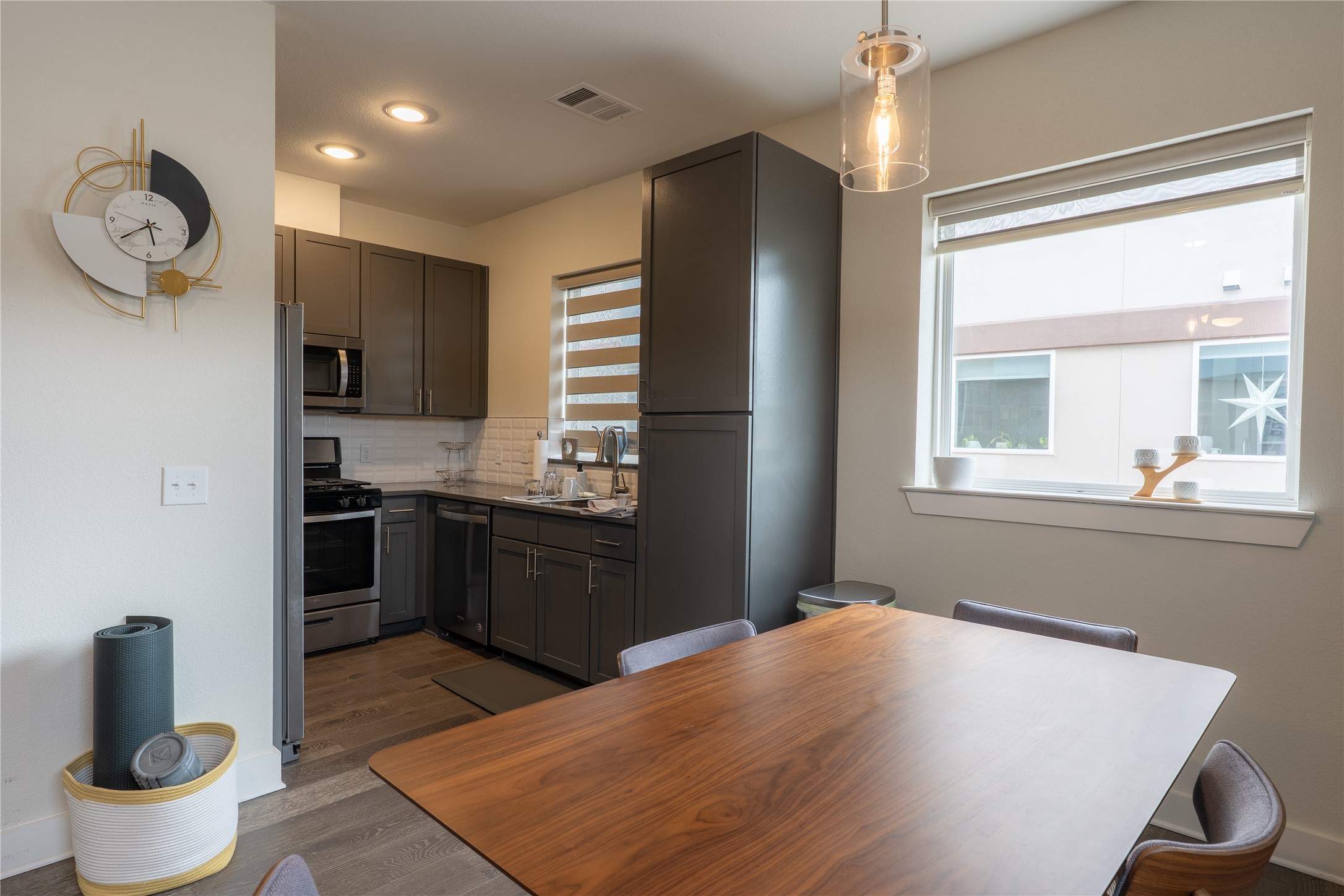 2827 Manor Road, Unit 4101 Austin, TX 78722 - Photo 11 of 38 The property features a kitchen with dark grey cabinetry, stainless steel appliances, and a white subway tile backsplash