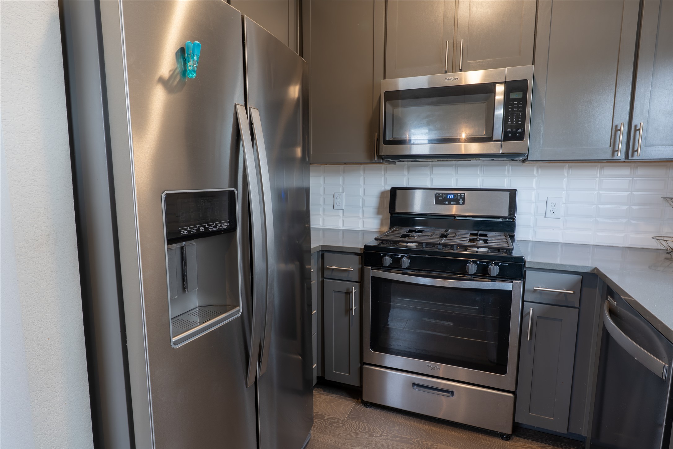 2827 Manor Road, Unit 4101 Austin, TX 78722 - Photo 17 of 38 The kitchen features stainless steel appliances, including a side-by-side refrigerator, gas range, and built-in microwave