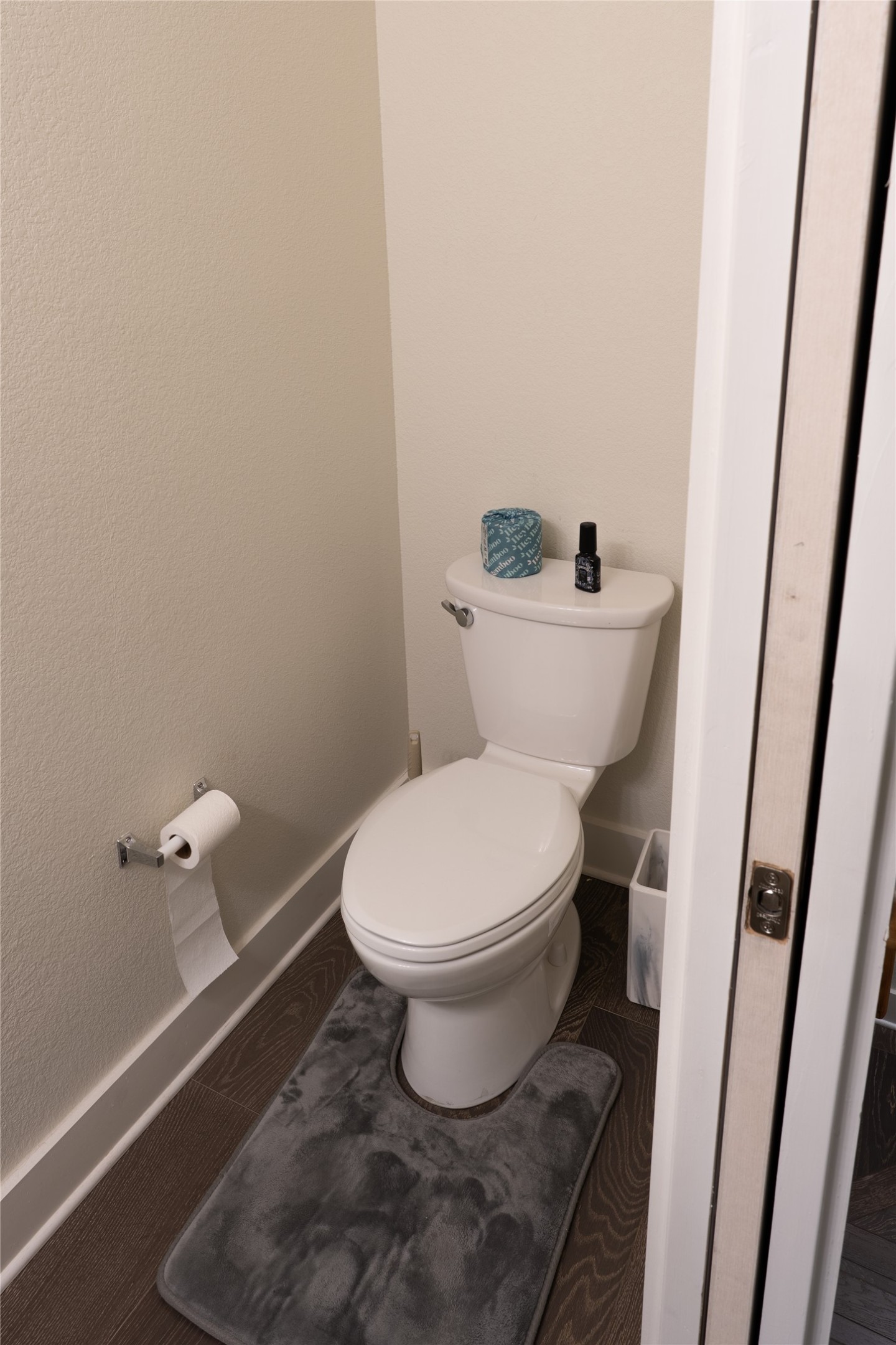 2827 Manor Road, Unit 4101 Austin, TX 78722 - Photo 2 of 38 Bathroom featuring a white toilet, dark wood-style flooring, and light-colored walls