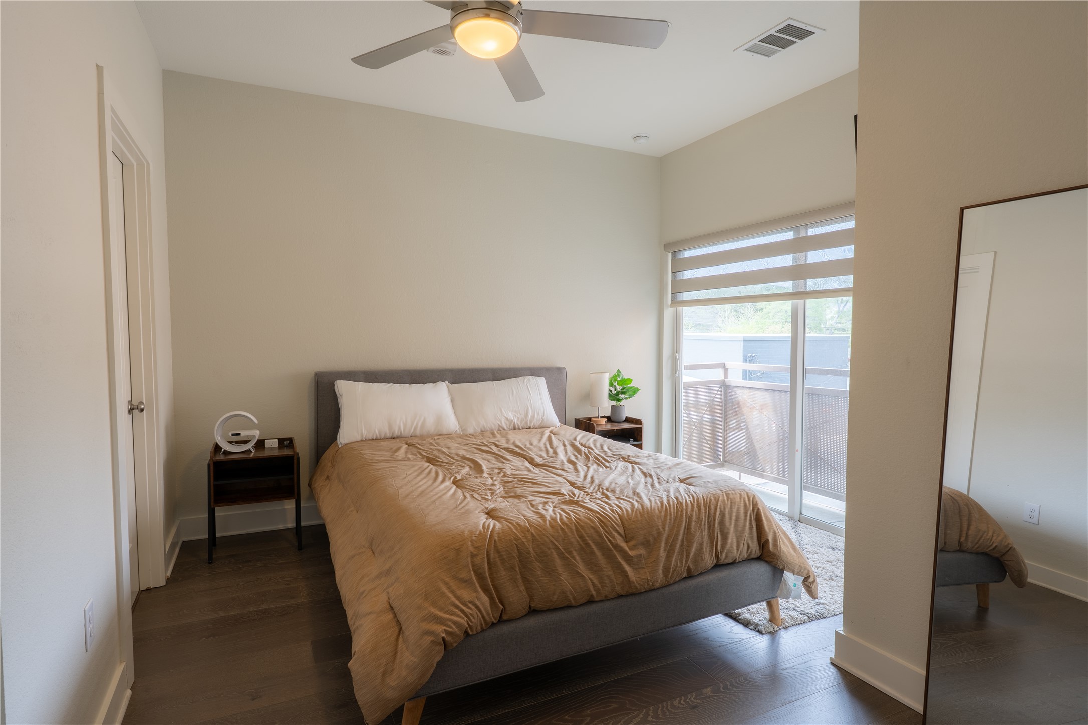 2827 Manor Road, Unit 4101 Austin, TX 78722 - Photo 25 of 38 Well-appointed room featuring dark hardwood floors, a modern ceiling fan, and a glass sliding door leading to an outdoor space