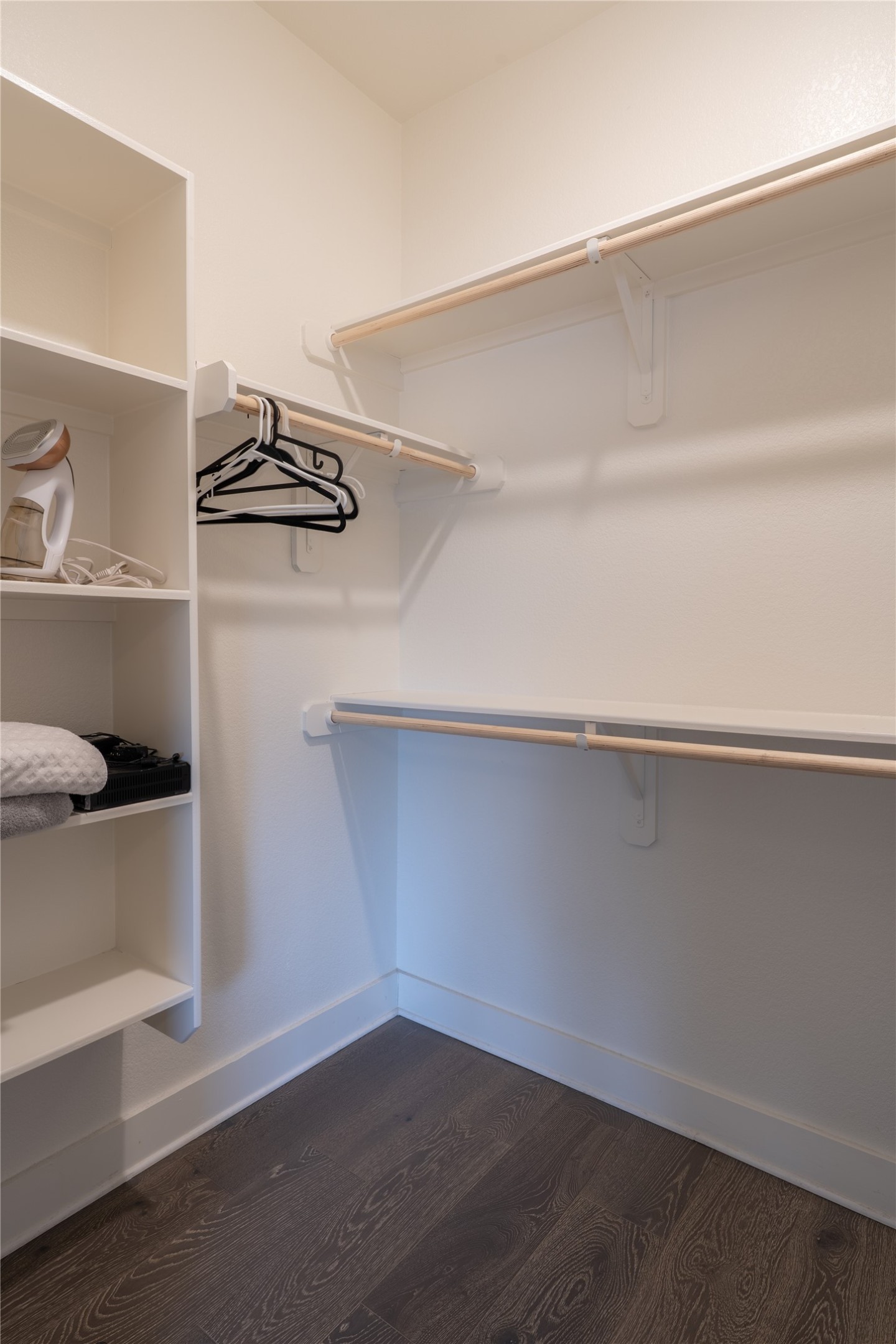 2827 Manor Road, Unit 4101 Austin, TX 78722 - Photo 26 of 38 The property features a walk-in closet with white shelving, hanging rods, and dark wood-style flooring