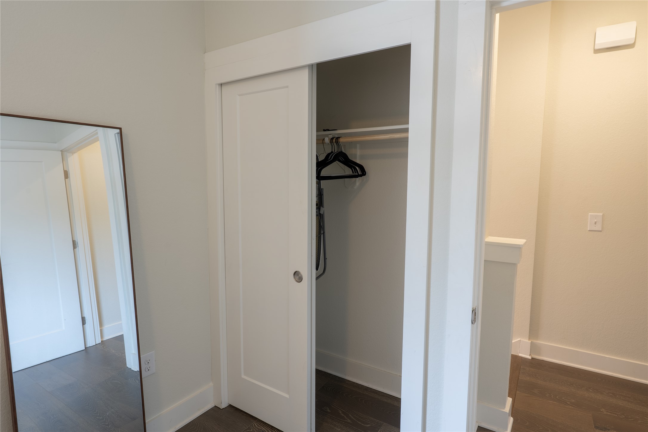 2827 Manor Road, Unit 4101 Austin, TX 78722 - Photo 28 of 38 Interior view featuring a closet with a sliding door, a clothing rod, and dark wood flooring
