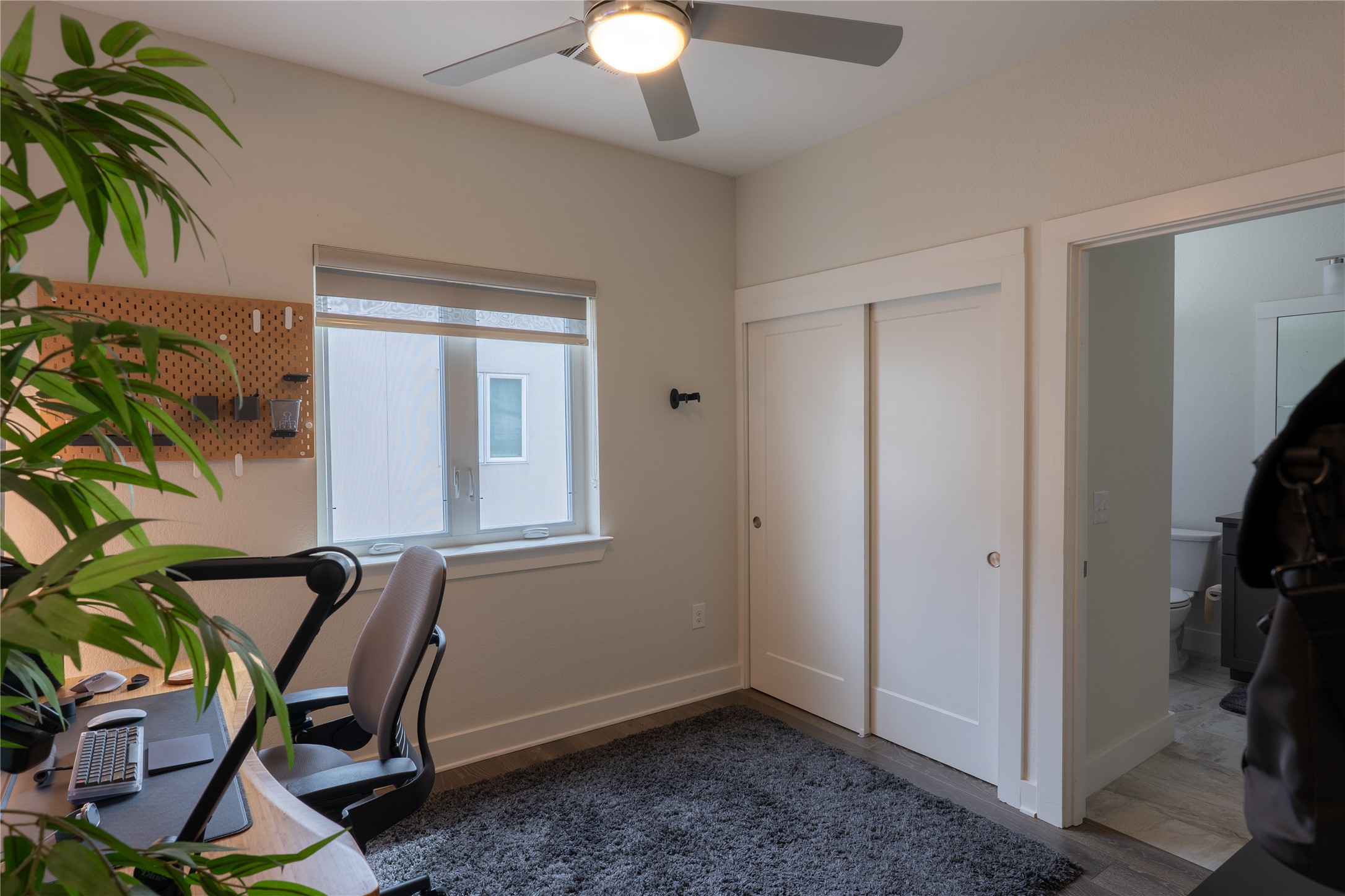 2827 Manor Road, Unit 4101 Austin, TX 78722 - Photo 34 of 38 This room features a ceiling fan, a window with blinds, and white sliding closet doors
