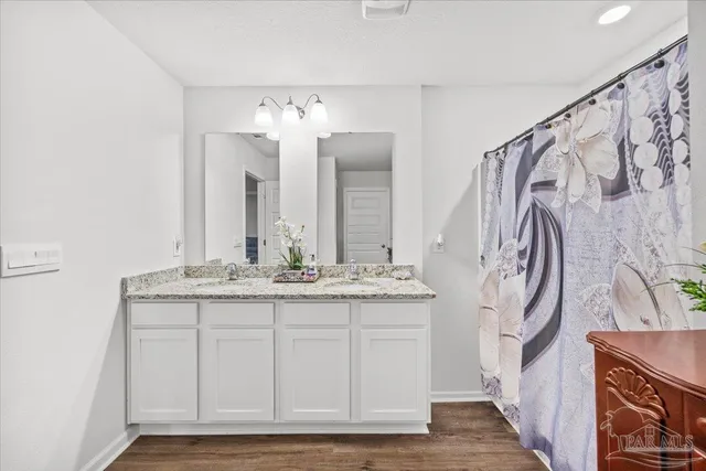 a bedroom with a bed a chandelier and a window