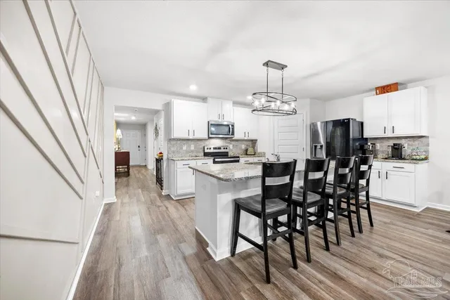 a kitchen with stainless steel appliances granite countertop a stove microwave and cabinets
