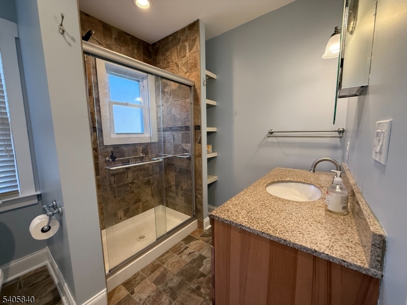 40 West Shore Road Denville, NJ 07834 - Photo 17 of 31 a bathroom with a granite countertop sink a mirror and shower