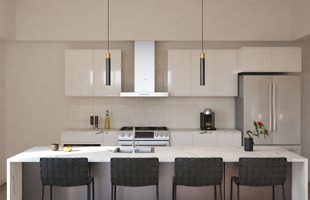 20 West Fifth Street, Unit PH6F Boston, MA 02127 - Photo 5 of 7 a kitchen with stainless steel appliances kitchen island granite countertop a table chairs microwave and sink
