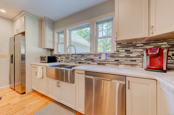 a kitchen with granite countertop cabinets stainless steel appliances and a wooden floor