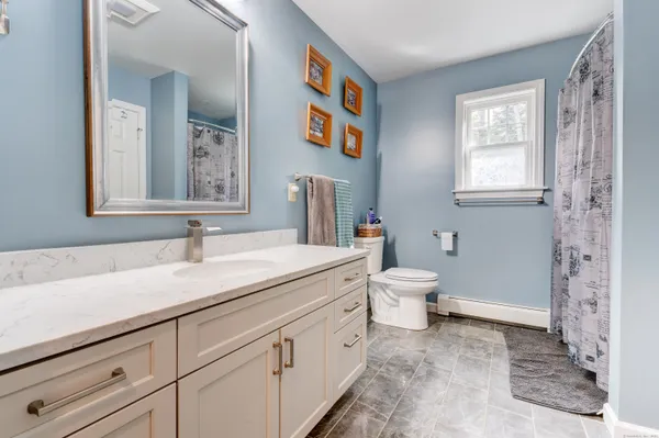 a spacious bathroom with a double vanity sink mirror and bathtub