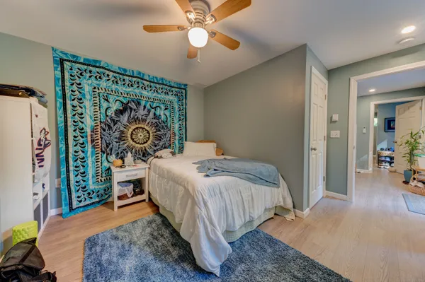 a bedroom with a bed and wooden floor