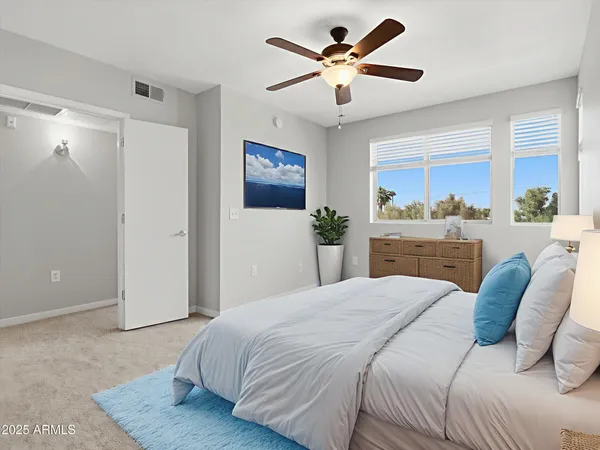 a spacious bedroom with a bed and a chandelier
