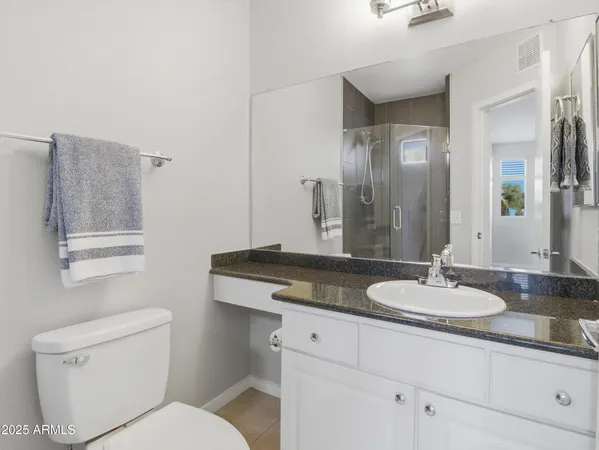 a bathroom with a granite countertop sink mirror and toilet
