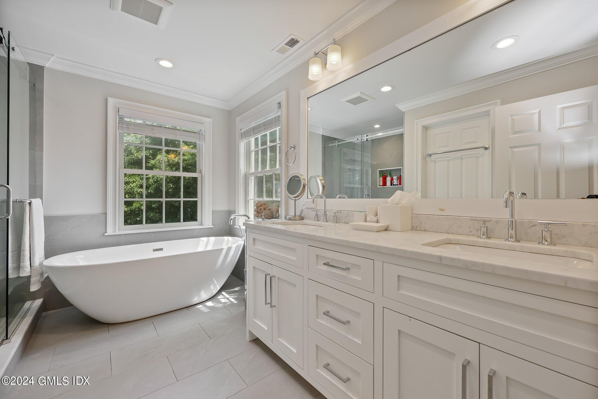 4 Grimes Road Old Greenwich, CT 06870 - Photo 11 of 22 a spacious bathroom with a double vanity sink a mirror and a bathtub