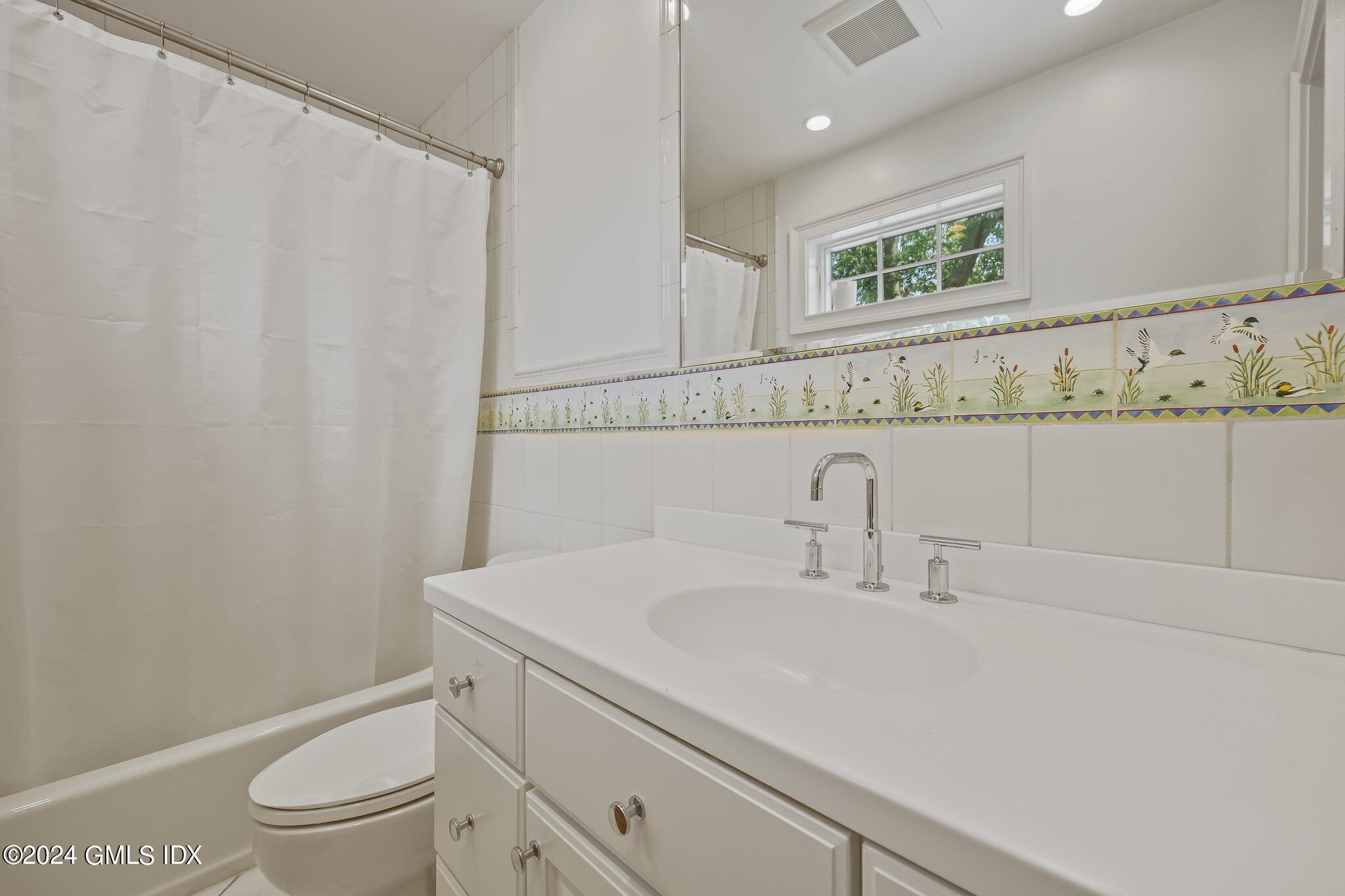 4 Grimes Road Old Greenwich, CT 06870 - Photo 14 of 22 a bathroom with a sink a toilet and a mirror