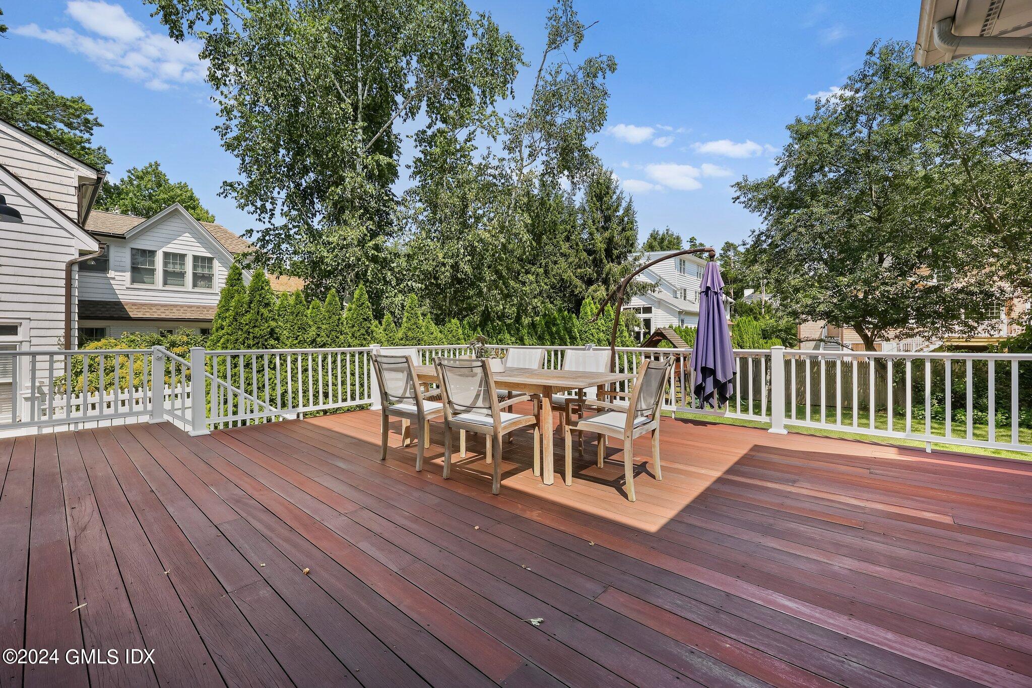 4 Grimes Road Old Greenwich, CT 06870 - Photo 17 of 22 a view of a deck with table and chairs and wooden floor