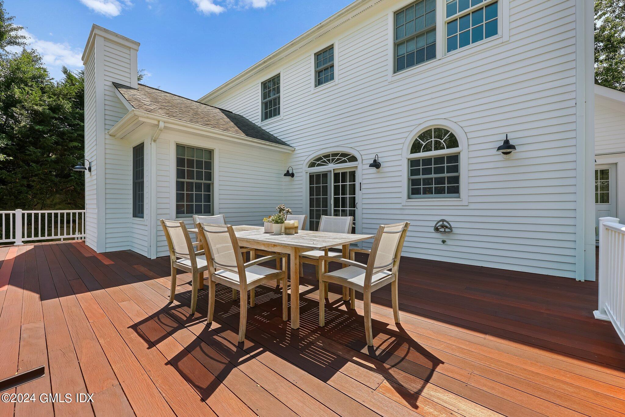 4 Grimes Road Old Greenwich, CT 06870 - Photo 18 of 22 a view of a roof deck with table and chairs and wooden floor