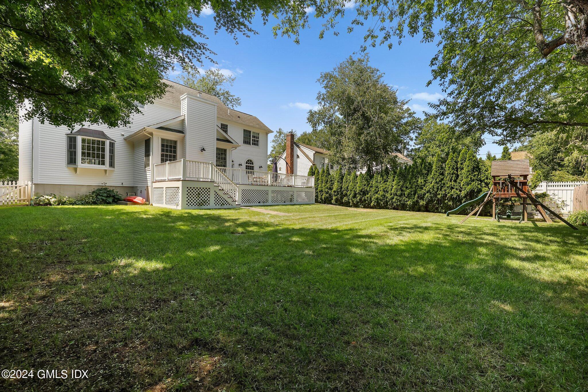 4 Grimes Road Old Greenwich, CT 06870 - Photo 19 of 22 a view of house in front of a big yard with large trees