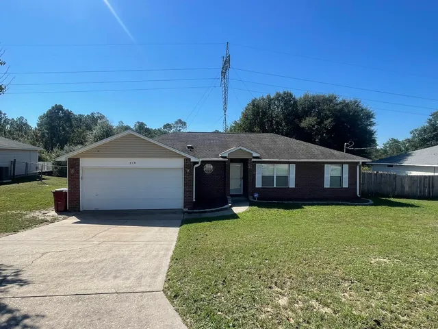 a front view of a house with yard and green space