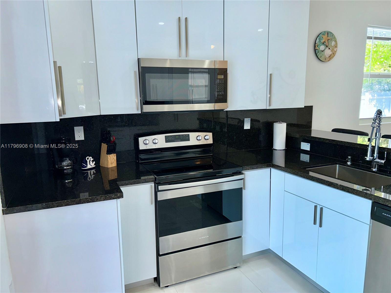 730 Largo Road Key Largo, FL 33037 - Photo 17 of 29 a kitchen with granite countertop white cabinets stainless steel appliances and a window