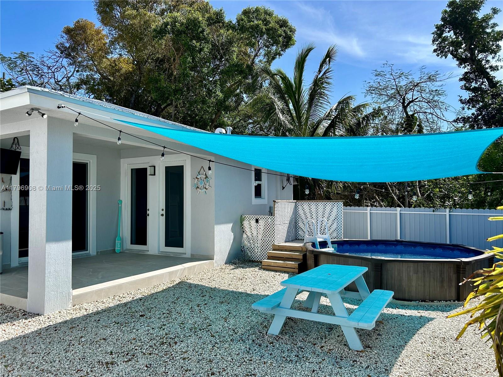 730 Largo Road Key Largo, FL 33037 - Photo 9 of 29 a view of a backyard with chairs and a small cabin