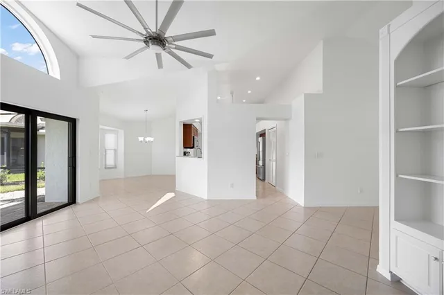 a view of a hallway with closet and a chandelier fan