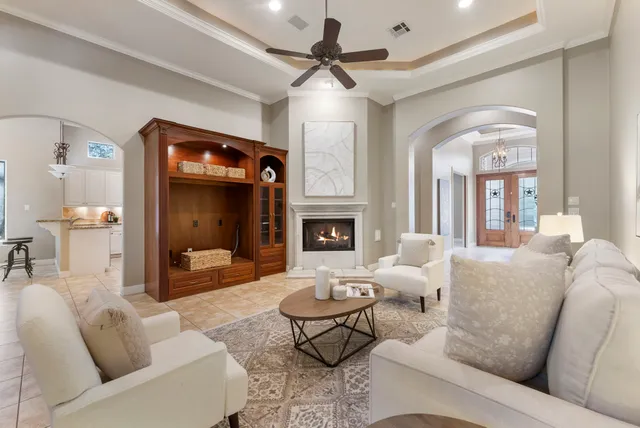 a living room with furniture a fireplace and a chandelier